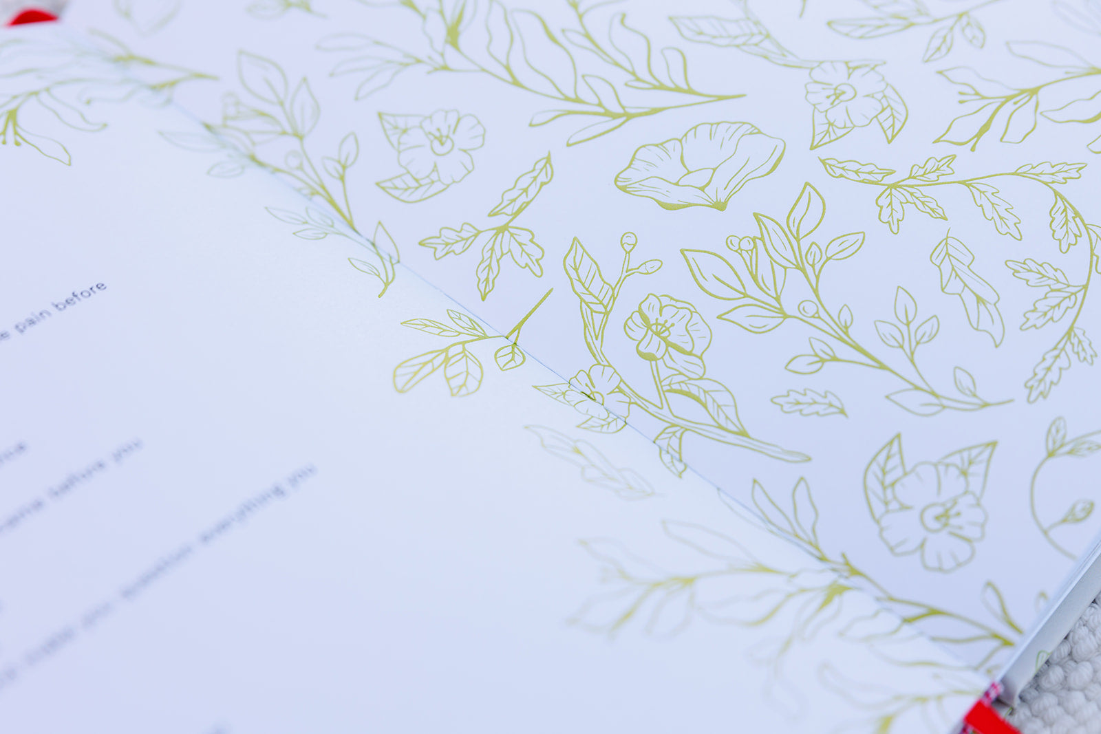 A close-up of an open planner featuring delicate green floral illustrations on the pages. The botanical design adds an elegant and nature-inspired touch, reflecting themes of growth, creativity, and intentional living.